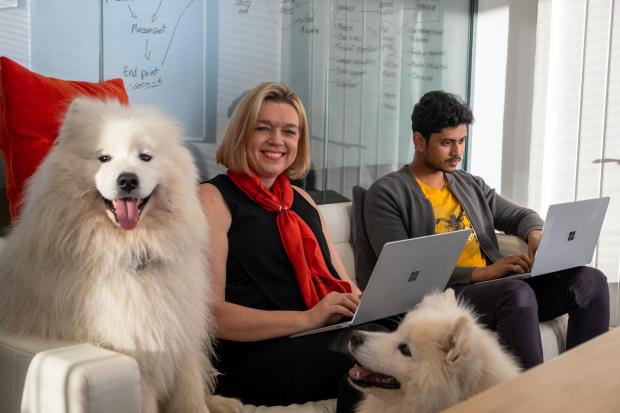 Carlene Jackson (c) Bear (l) Shaska (r) Vignesh (far right) Kayla Charlton.jpg.article-620 Happy colleagues with a big fluffy white dog - dog-friendly workplace