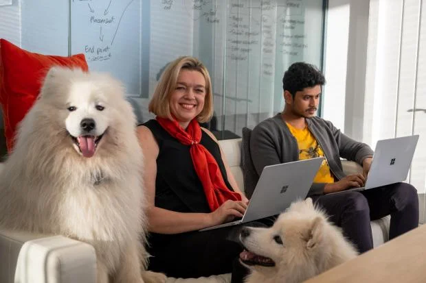 Carlene Jackson (c) Bear (l) Shaska (r) Vignesh (far right) Kayla Charlton.jpg.article-620 Happy colleagues with a big fluffy white dog - dog-friendly workplace