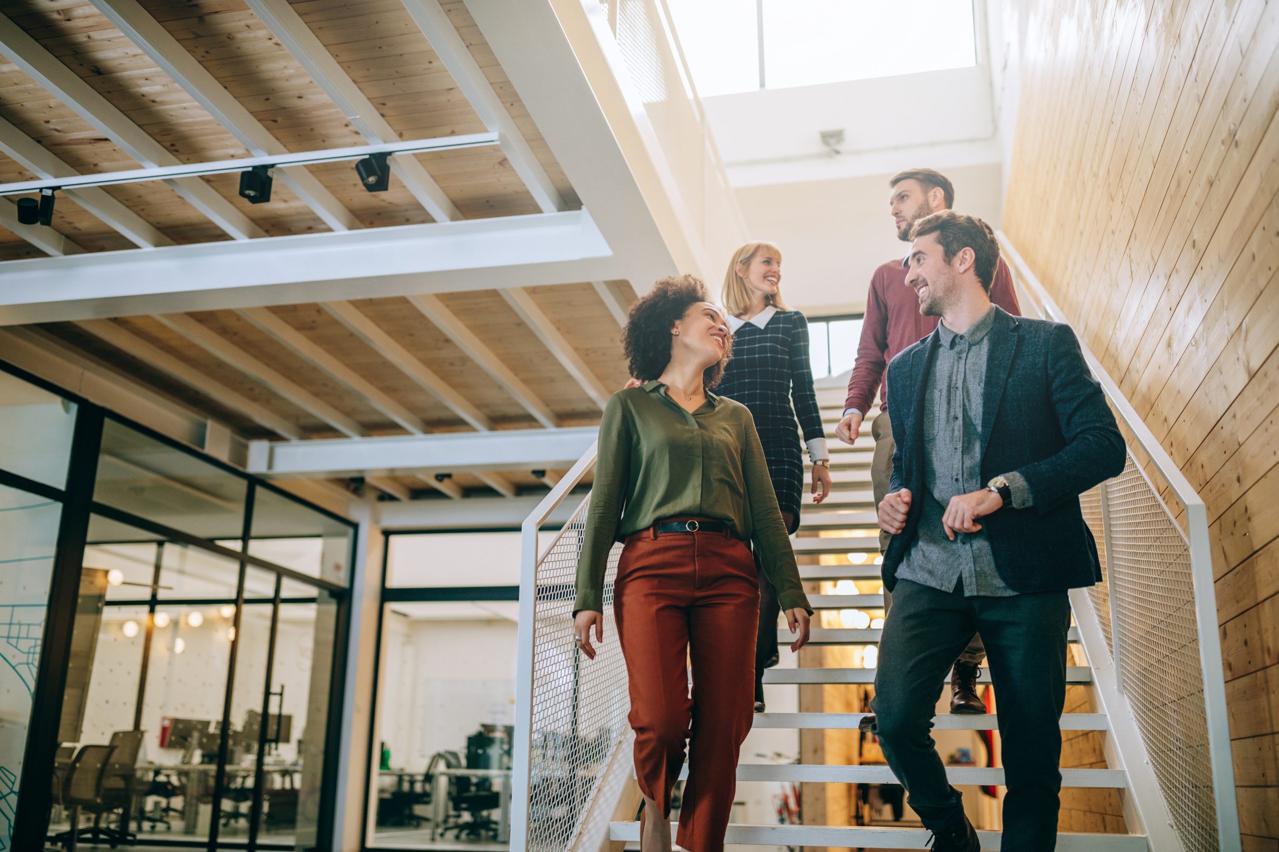 It's not difficult to find a good team Group of diverse coworkers walking down the stairs in an office