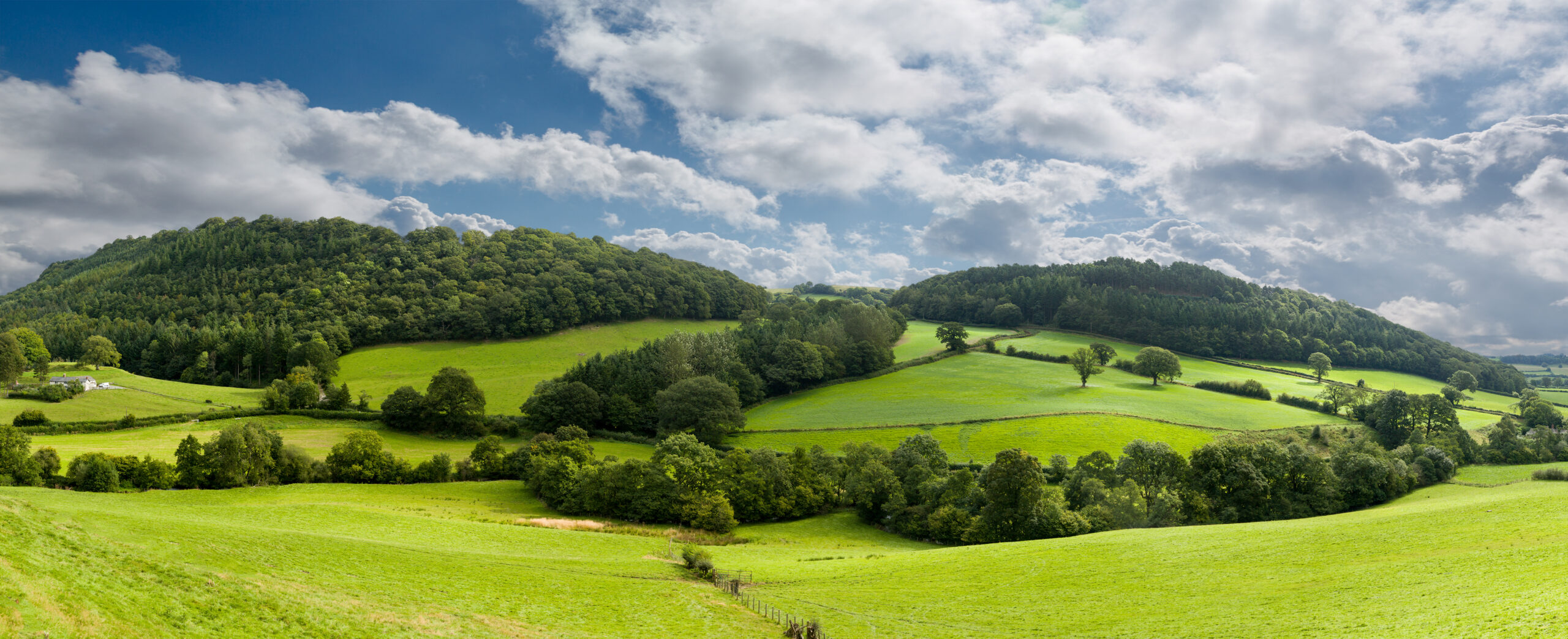 Broad panorama of the countryside in North Wales with green field in foreground