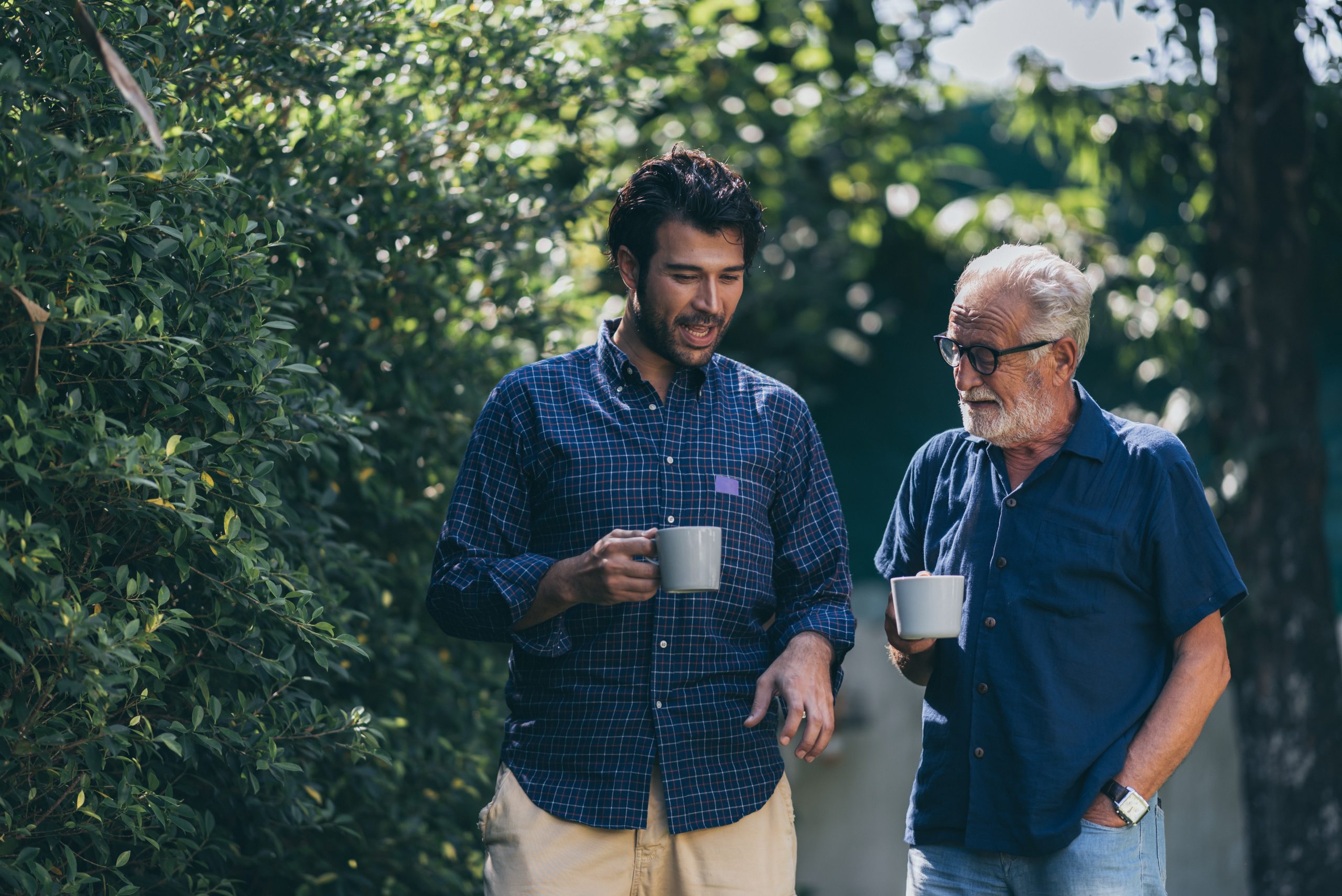 An adult hipster son and senior father at home, talking. An adult hipster son and senior father at home, talking.