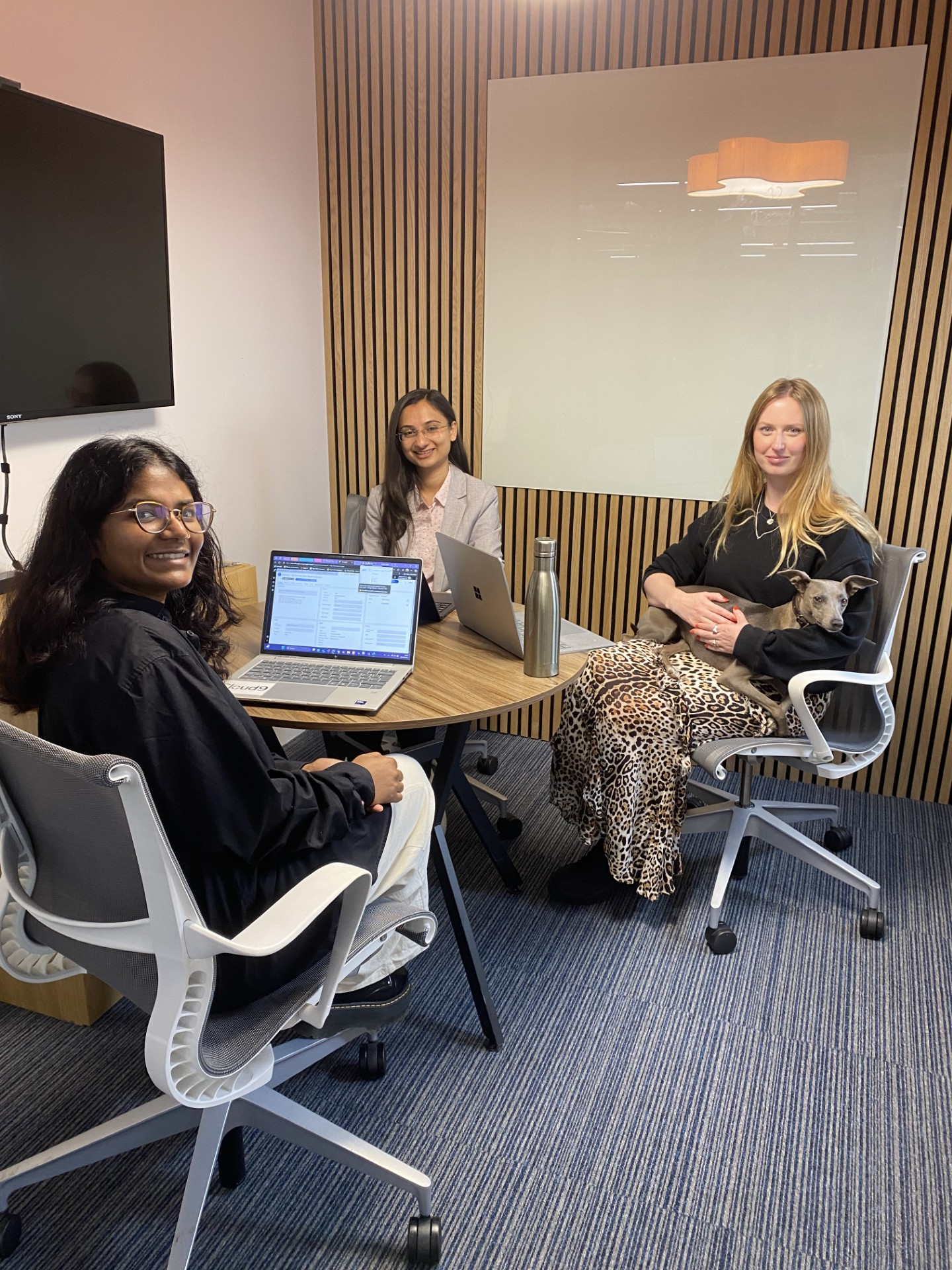 colleagues around a desk with a dog