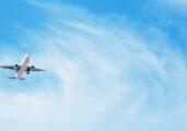 Beautiful Panoramic Background with flying plane in blue sky. Passenger airplane with landing gear released takes off in sky. Travel concept. Wide Angle Wallpaper or Web banner With Copy Space
