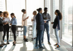 Full length motivated millennial african american colleagues employees managers communicating in small groups, enjoying break time in modern office room, networking enjoying teambuilding activity