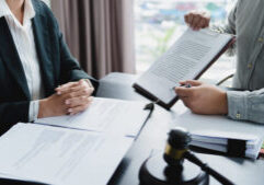 Labor law concept. Lawyer signing legal document with Judges gavel.