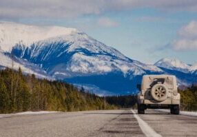 jeep on a road with a mountain in the background
